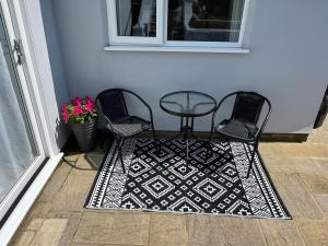 a table and two chairs on a rug next to a door at The A in Walmer