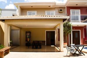 a patio of a house with a table and chairs at Casa com piscina no Botânico in Ribeirão Preto
