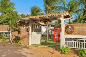 杰里科科拉FlowHouse Jeri - Hotel & Coworking的房子前面有一个红色电话亭,还有红色电话亭