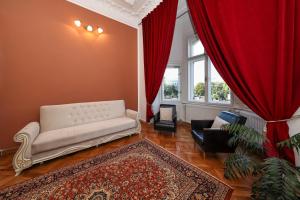 a living room with a white couch and red curtains at La Maman- Only self check-in in Braşov +16 photos