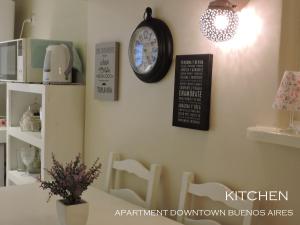 eine Uhr an der Wand eines Zimmers mit Stühlen in der Unterkunft A & E Buenos Aires in Buenos Aires