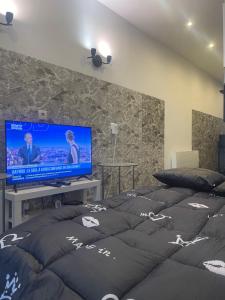 a bedroom with a flat screen tv and a bed at Près de l aéroport Orly Parking gratuit in Villeneuve-le-Roi