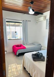 a bedroom with two beds and a window at Geribá - casa plana, conforto, adaptada e tudo a pé in Búzios +29 photos