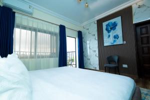 a bedroom with a white bed and a window at Canaan Residences by American Embassy in Freetown