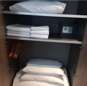 a closet with white towels and a pile of towels at Apartment Aleksandar AS in Brzeće