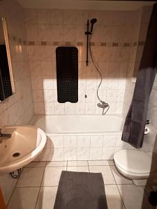 a bathroom with a tub and a toilet and a sink at Appartement Stein 1 OG in Fritzlar +10 photos