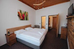 Un pat sau paturi într-o cameră la Penzion Mona Rooms & Apartments
