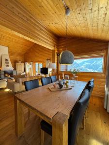 a dining room with a wooden table and chairs at Chalet Toccata, cosy et lumineux in Les Diablerets