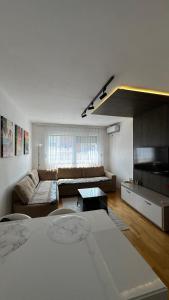 a living room with a couch and a table at X apartment - Charming 1BR Retreat apartment in Pristina