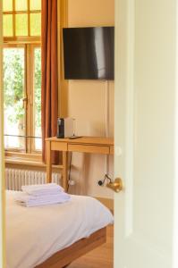 a room with a bed and a desk with a television at Den Eikenboom in Loenen