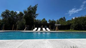 a swimming pool with chairs and a slide at Inspiramide Pucon in Pucón