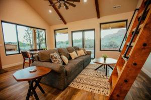 a living room with a couch and some windows at Casa Vermillion Modern Kanab Family Cabin Red Rock Views Near Zion in Kanab