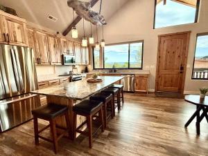 a large kitchen with a large wooden table and chairs at Casa Vermillion Modern Kanab Family Cabin Red Rock Views Near Zion in Kanab