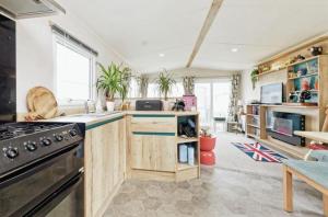 a kitchen with wooden cabinets and a stove at Lovely 2 bedroom holiday home in Whitstable in Chestfield