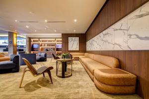a hotel lobby with a couch and chairs at Wyndham Santiago Aeropuerto in Santiago