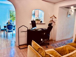 a living room with a desk and a table with a computer at Ruhe & Erholung im Grünen! Mediterranes Landhaus-Apartment mit Jacuzzi für bis zu 4 Personen in Merchweiler +33 photos