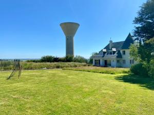 a large yard with a water tower in the background at Côte d'Opale 8-10 personnes in Audembert