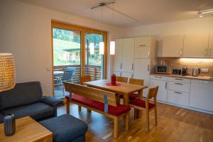 a kitchen and living room with a table and a couch at Triebenstein Hideaway in Hohentauern