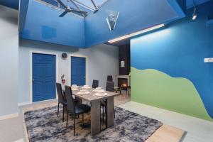a dining room with blue walls and a table and chairs at Tranquil 3-Bedroom Home in Prince George in Prince George
