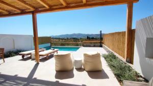 a patio with a table and chairs and a pool at IraΜar Luxury Villa I Paros in Kampos Paros