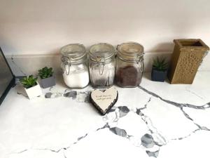 a group of jars sitting on a counter with plants at Skool House Retreat - 9 bedroom option in Bodham