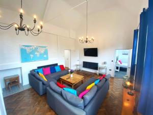 a living room with a couch and a table at Skool House Retreat - 9 bedroom option in Bodham