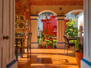 a hallway with a table and chairs in a room at Hotel Nolasco in Antigua Guatemala