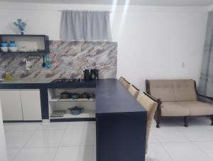 a kitchen with a black counter and a couch and a television at Um lugar para recordar in São José dos Campos