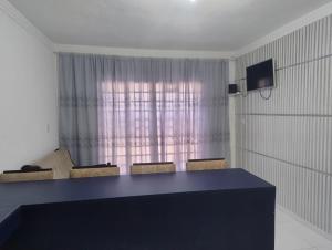 a room with a table and chairs and a curtain at Um lugar para recordar in São José dos Campos
