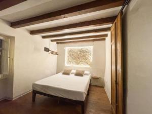 a small bedroom with a bed and a window at Kalma Elephant Tower - Medieval Stay with a City View in Cagliari +2 photos