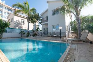 a swimming pool in front of a building at Konnos Villa Ekaterina in Protaras