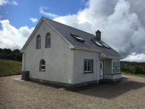 a small white house sitting on top of a driveway at Breathtaking view in Carrigart