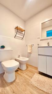 a white bathroom with a toilet and a sink at Premium Studio in Downtown in Neuquén