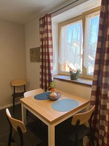 a table and chairs in a room with a window at Lussari Style Apartments in Tarvisio