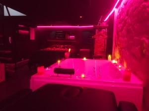 a room with a hot tub with candles in it at La Cachette Secrete - Love Room à Caen en Normandie avec Balnéo et Sauna Privatif in Caen