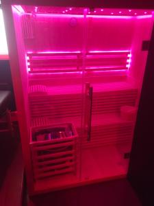 a refrigerator with a pink light in a room at La Cachette Secrète - Maison romantique avec Balnéo et Sauna Privatif à Caen en Normandie in Caen