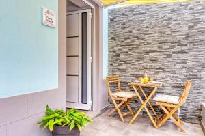 stół i krzesła na patio z ceglaną ścianą w obiekcie Casa da Tia Celeste III, a Home in Madeira w mieście Ponta do Sol