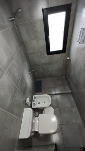 a small bathroom with a toilet and a window at Calixto C in Cordoba +1 photo