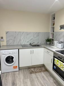 a kitchen with a sink and a washing machine at Room 3 - En-suite for 2 people in London