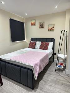 a bedroom with a large bed with a pink blanket at Room 3 - En-suite for 2 people in London