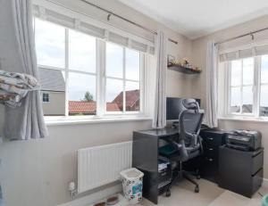a room with a desk and a chair and windows at CrastaPrade LUXHolidayHome in Celerina
