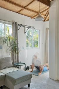 ゼネラル・ルナにあるSpacious Family Home in General Luna Center with Wi-Fi, AC and Generatorのリビングルームのヨガマットの上に座っている男性