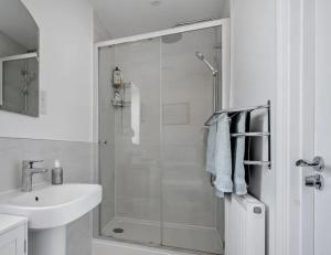 a white bathroom with a shower and a sink at CrastaPrade LUXHolidayHome in Celerina +6 photos