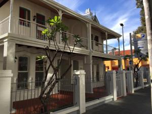 a white house with a fence in front of it at Hay Street Traveller's Inn in Perth