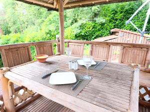 a wooden table with glasses and napkins on a deck at Coulounieix Resort in Coulounieix-Chamiers