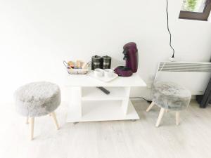 a white table with two stools and a white table and chairs at Coulounieix Resort in Coulounieix-Chamiers