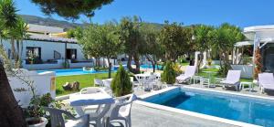 a resort with a pool and tables and chairs at Petite Economy Lodge in Skiathos