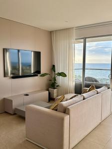 un soggiorno con due divani bianchi e una TV di Luxury Apartment betwen Cartagena and Barranquilla a Juan de Acosta