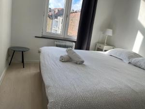 a stuffed animal is sitting on the edge of a bed at Flat brussels center in Brussels