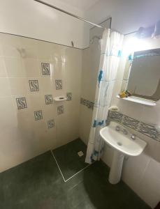 a white bathroom with a sink and a mirror at Lo de Alicia 1 in Estancia Vieja